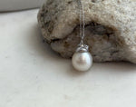 Luminous white South Sea pearl paired with a decorative sterling silver bail and cap.