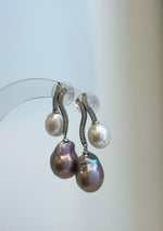 Close-up of lustrous rose purple and white Keshi pearls on sterling silver drop earrings.