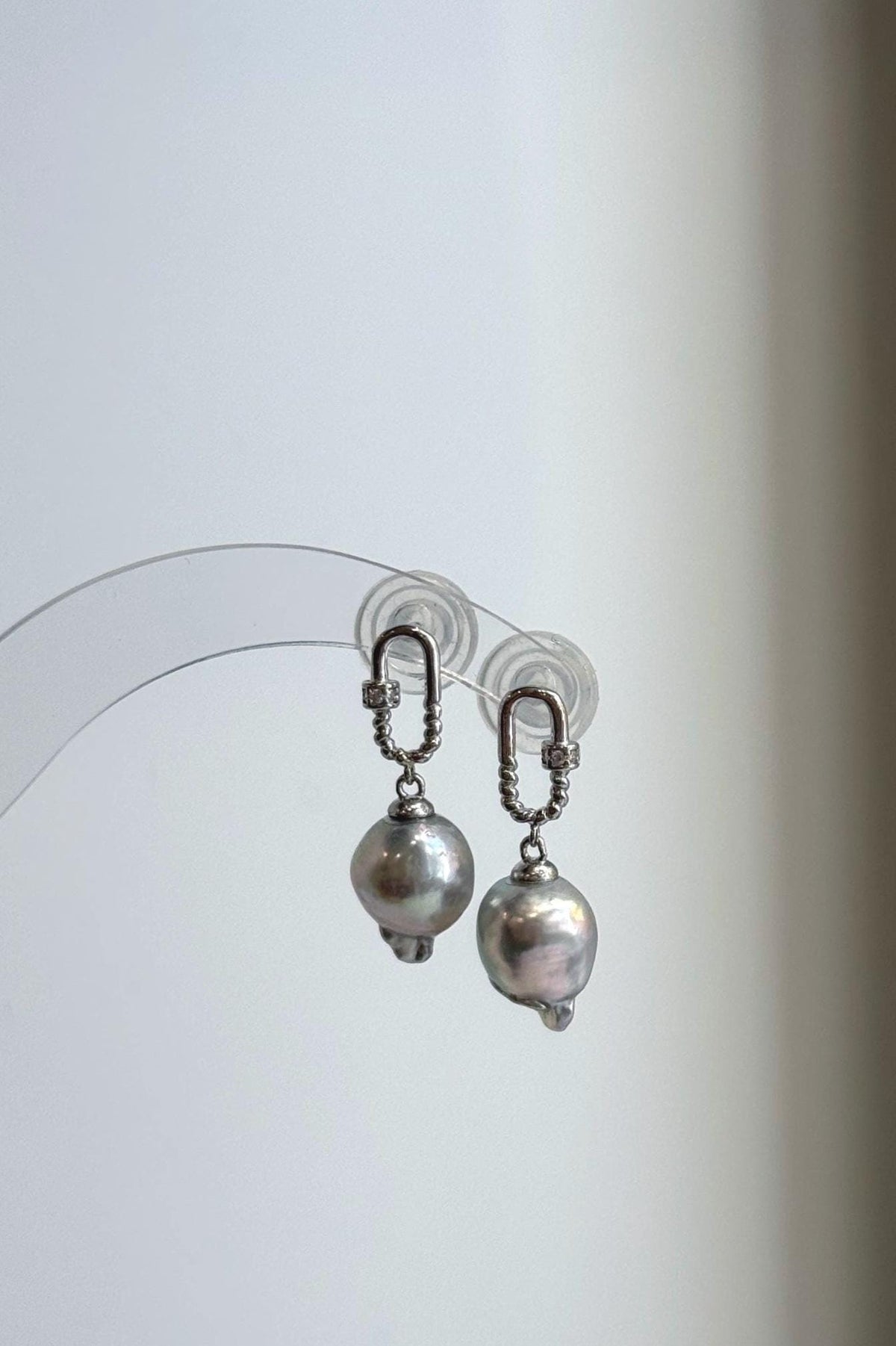 Akoya ocean pearls paired with decorative sterling silver carabiner-style earring settings.