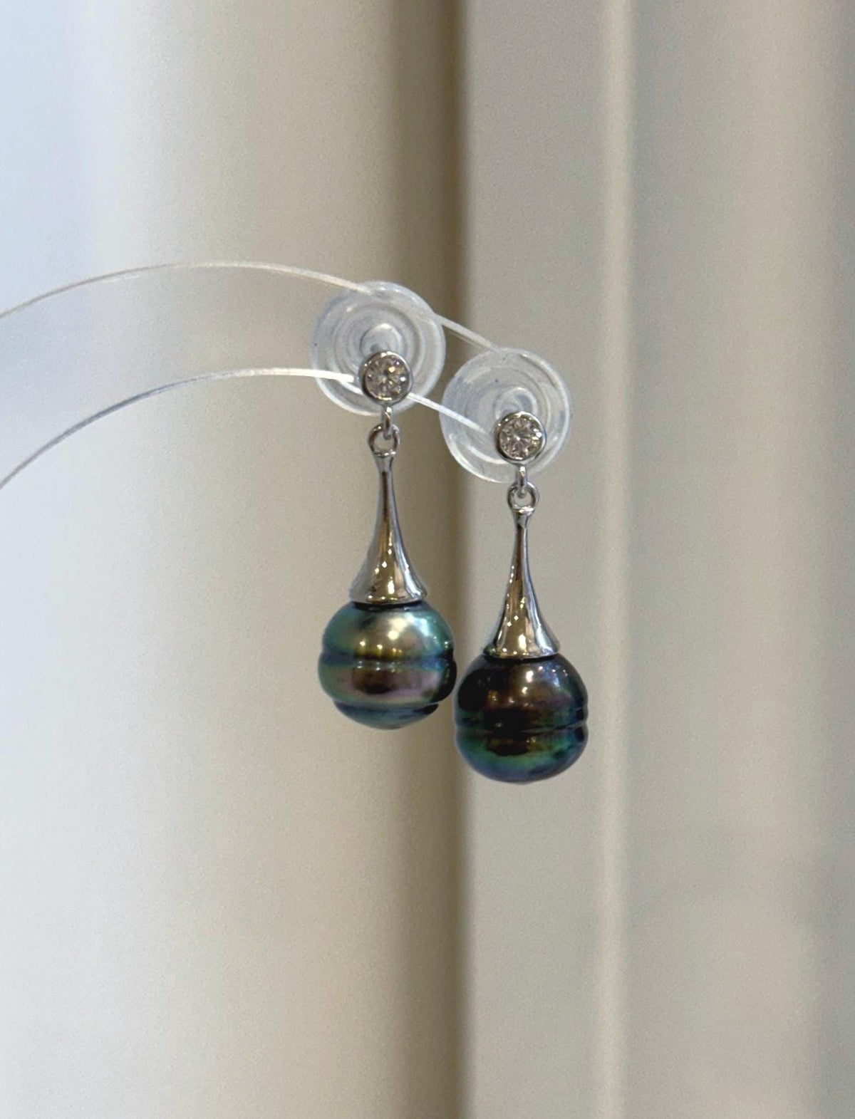 Front view of peacock green pearl earrings with a sleek, contemporary look.