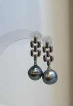 Elegant platinum-tone Tahitian pearl drops with bright reflections across their surfaces.