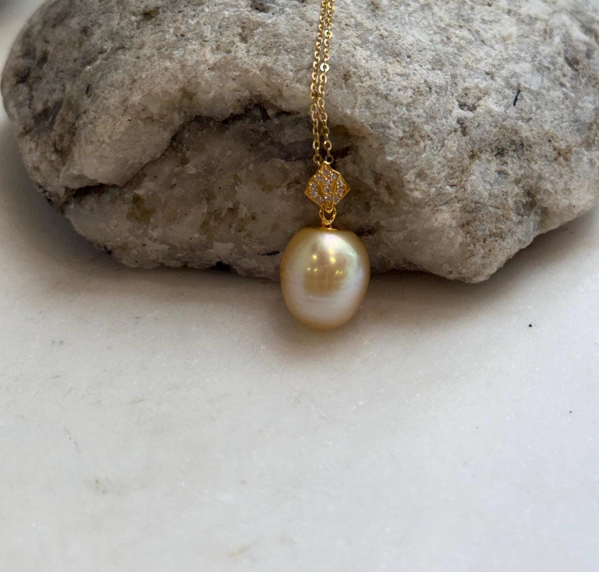 South Sea saltwater pearl pendant displayed against a pale sculptural background.