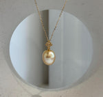 South Sea saltwater pearl pendant displayed against a pale sculptural background.