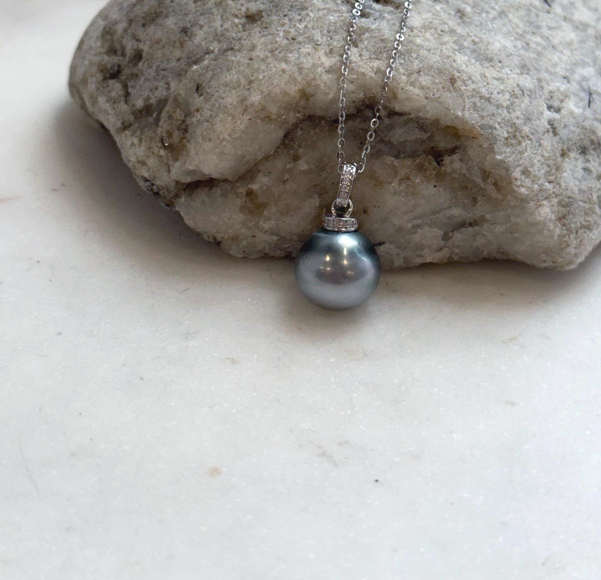 Tahitian pearl pendant set beneath a sparkling crystal-accented silver bail