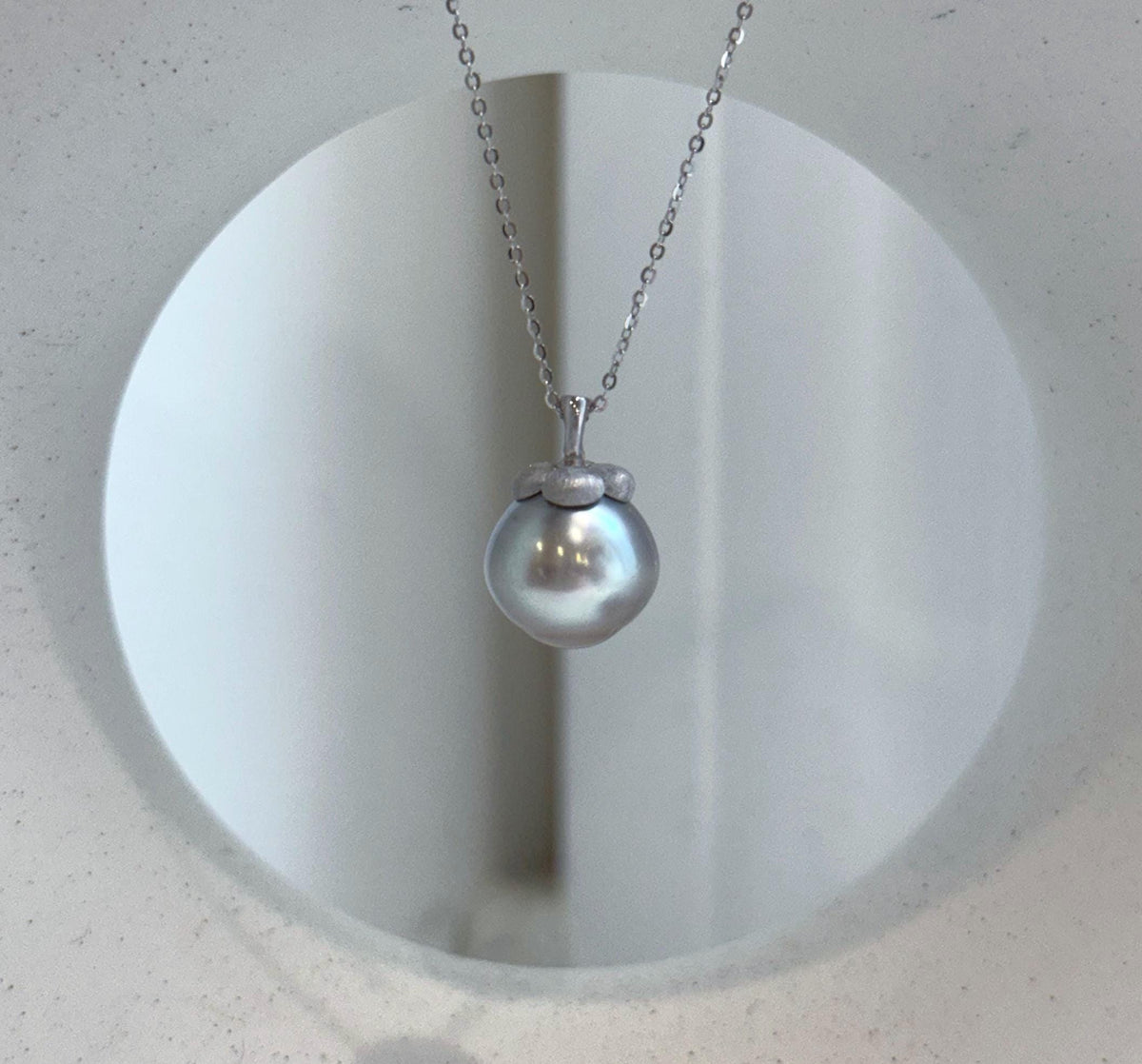Front view of the silver taupe pearl persimmon pendant necklace.