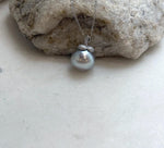 Side view showing the pearl and sculpted sterling silver setting.