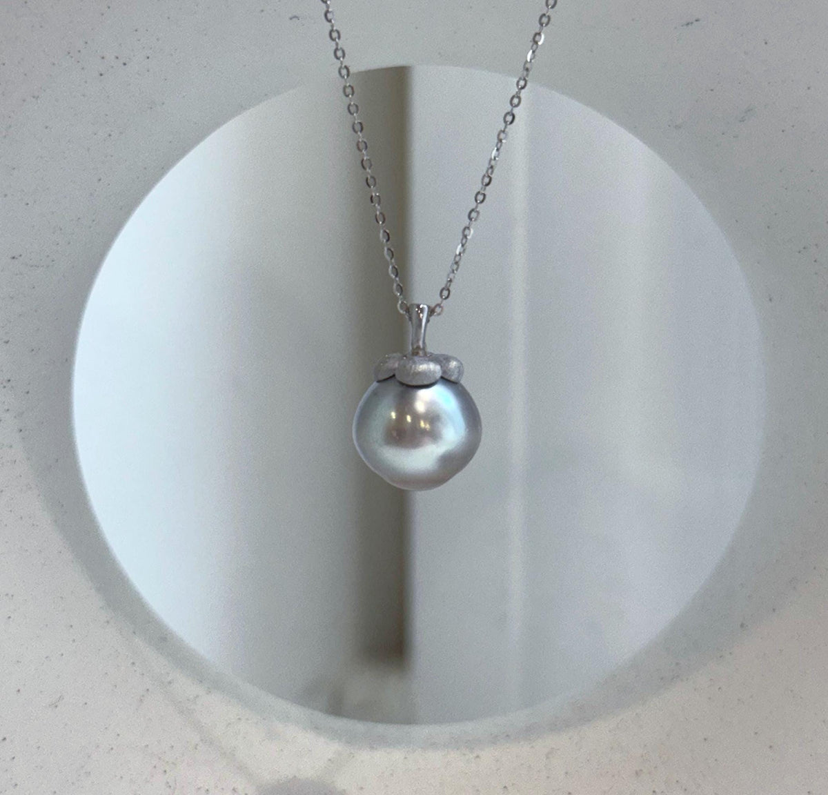 Lustrous pearl pendant with a playful persimmon-inspired design.