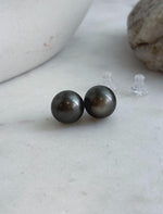 Classic saltwater pearl stud earrings with mirror luster and sterling silver settings.