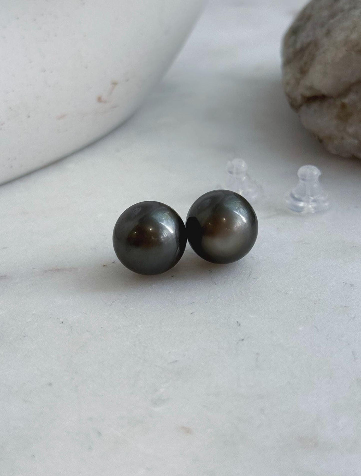 Classic saltwater pearl stud earrings with mirror luster and sterling silver settings.