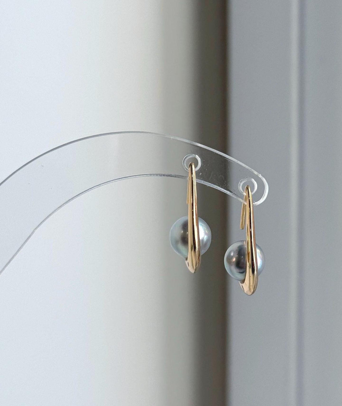 Genuine saltwater Akoya pearls suspended from sterling silver earring hooks.