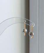 Genuine saltwater Akoya pearls suspended from sterling silver earring hooks.