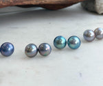 Minimalist sterling silver earrings featuring iridescent saltwater Mabe pearls.