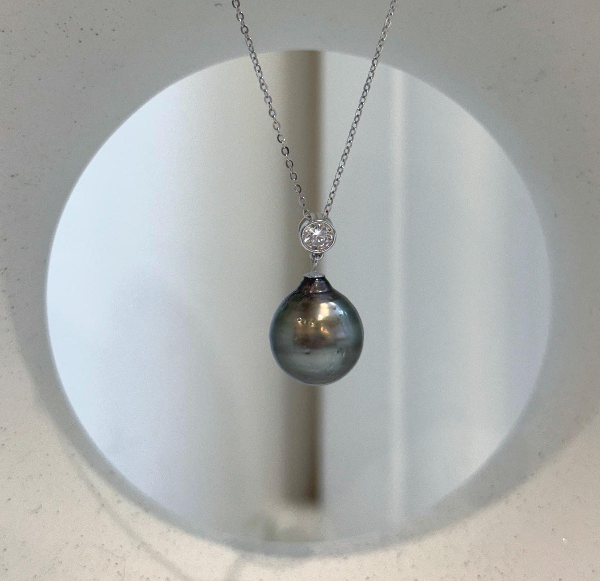 Genuine Tahitian pearl pendant with rich peacock green tones.