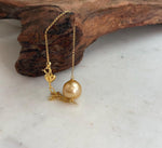 Gold-tone heart charm on pearl bracelet.