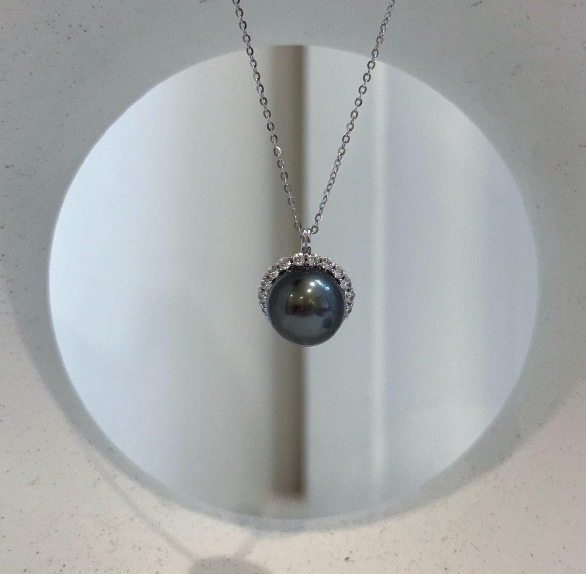 Elly’s piano black Tahitian pearl crystal halo necklace.
