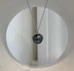 Dark saltwater pearl with blue-green reflections and crystal accents.