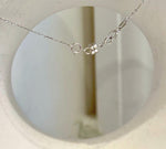 Mirror-luster black pearl framed by clear crystals.