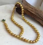 Lustrous golden freshwater pearls strung into a long necklace.