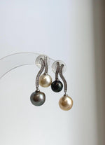Golden, peacock green and silver pearls with lustrous surfaces.