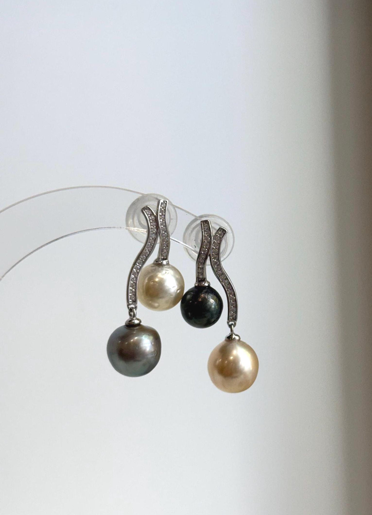Golden, peacock green and silver pearls with lustrous surfaces.