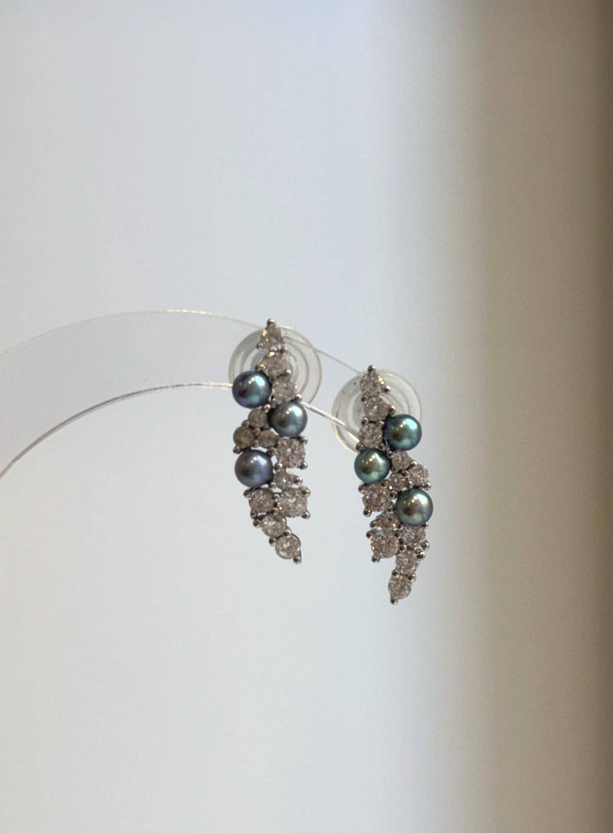 Dark freshwater pearls with teal and violet overtones in silver leaf settings.