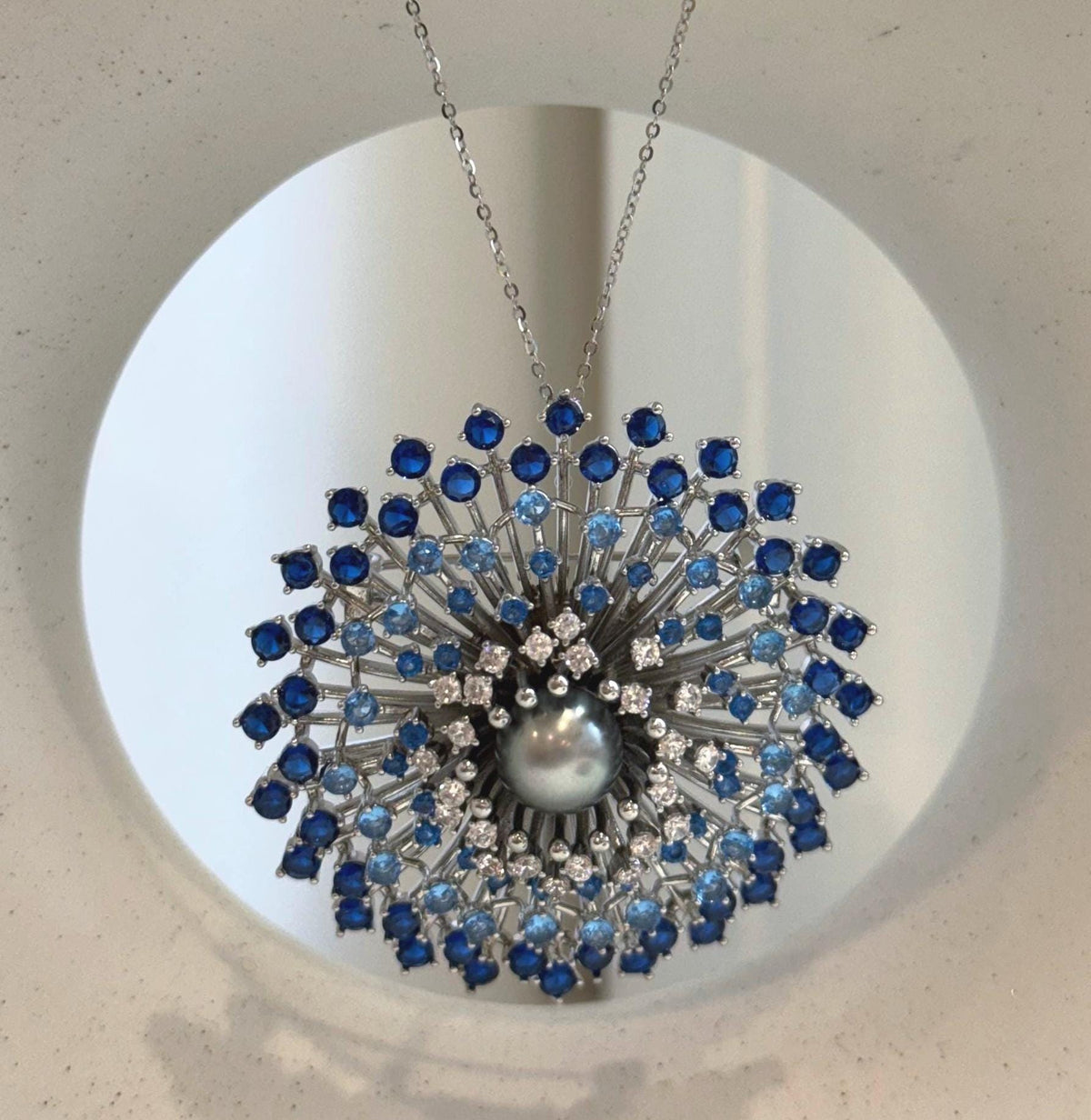 Tahitian pearl jewelry with light blue, dark blue, and clear stone accents.