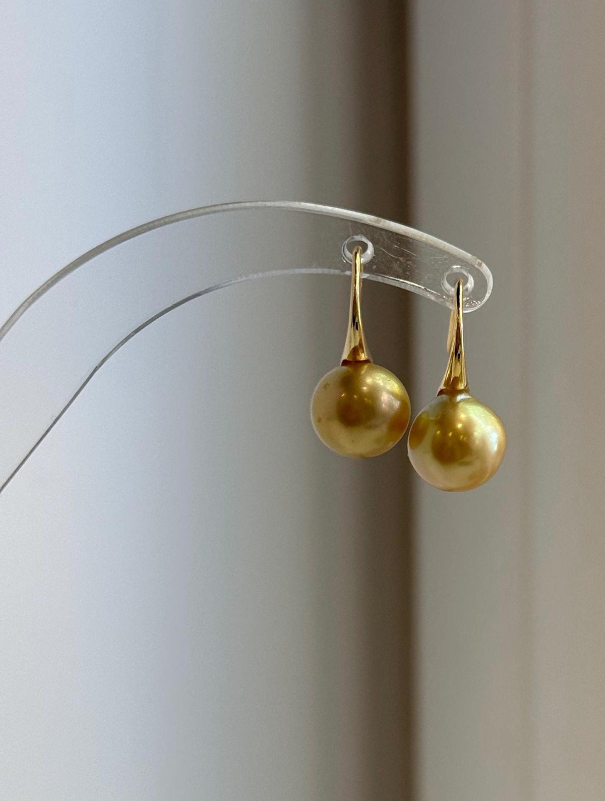 Genuine golden pearls suspended from sterling silver hooks.