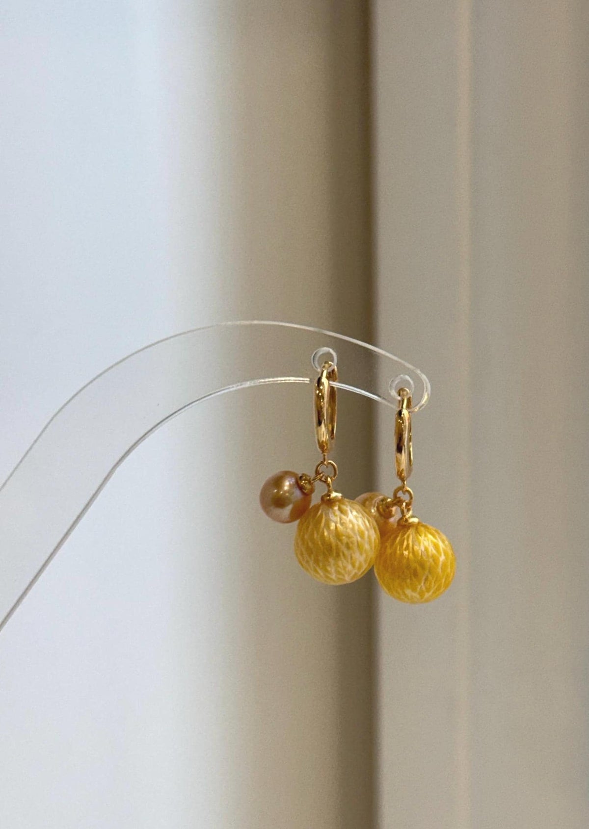 Carved South Sea and freshwater pearl drop earrings on silver hoops.