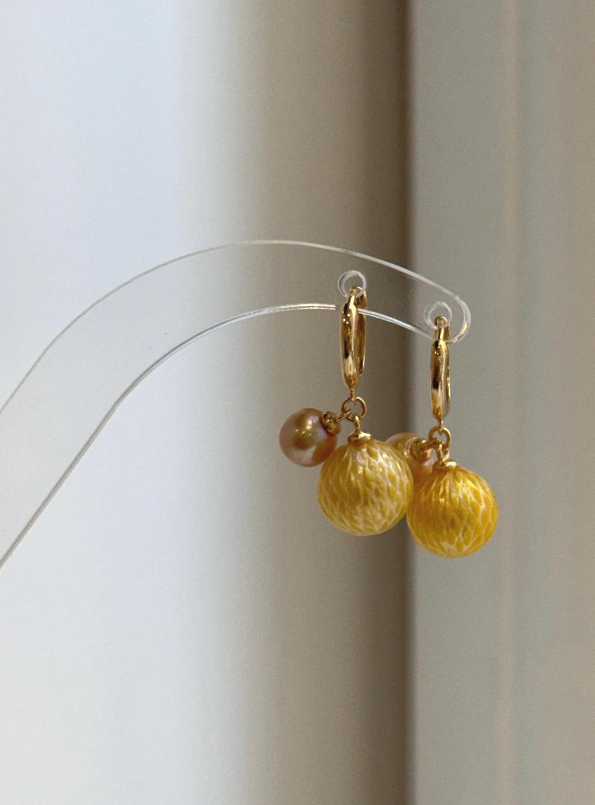 Silver hoop earrings featuring carved South Sea pearls.
