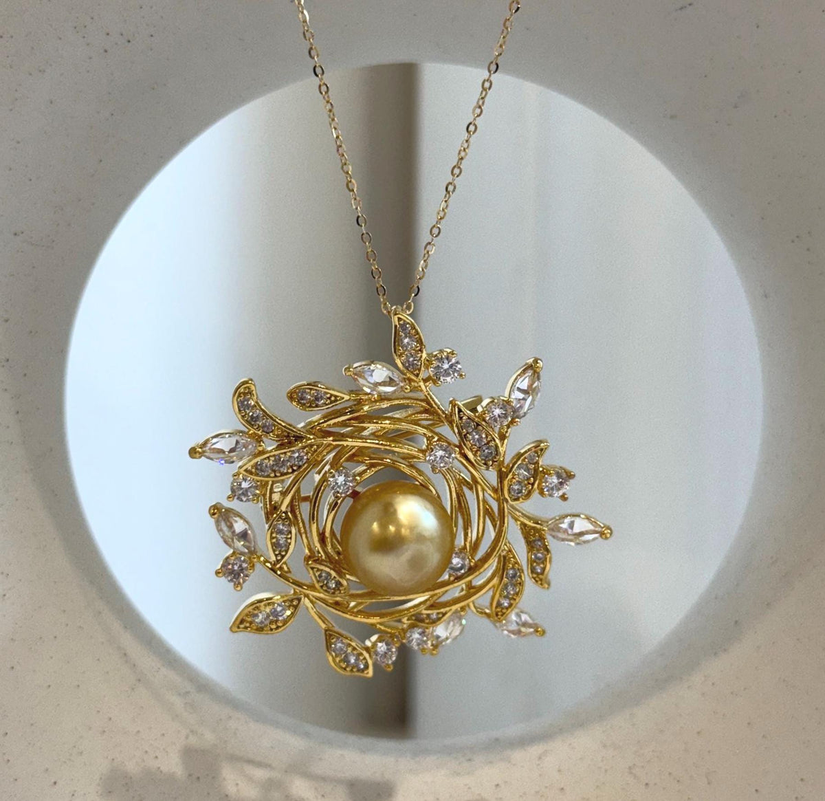 South Sea pearl surrounded by intertwined gold-tone branches