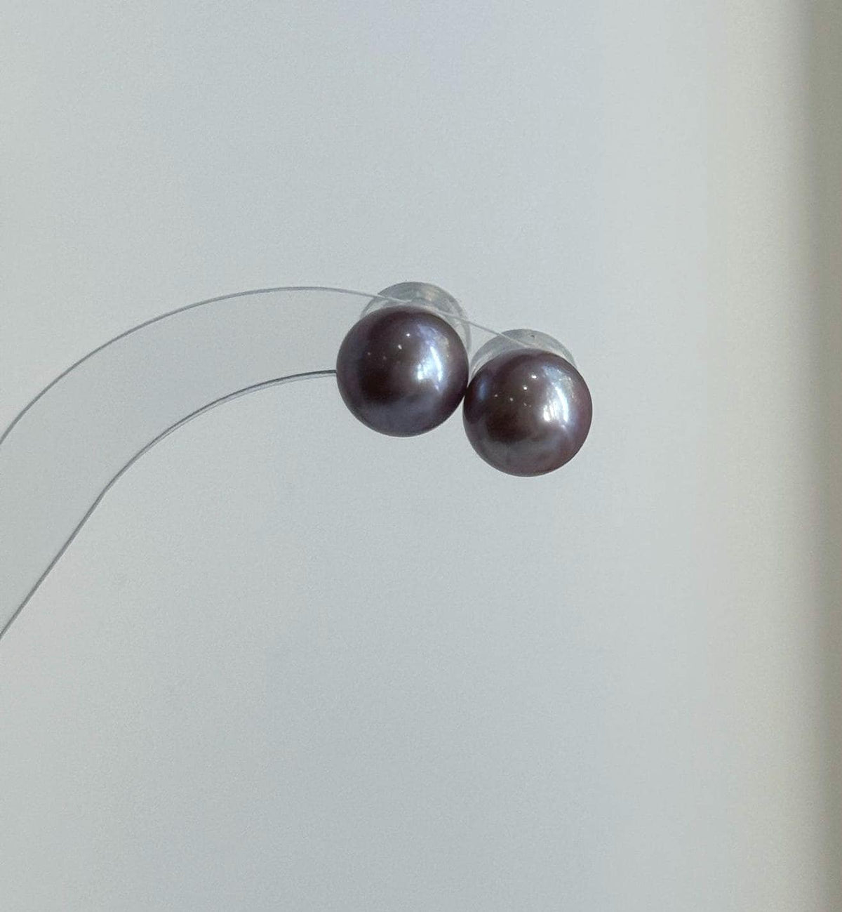 Purple Edison pearl jewelry set displayed beside a textured stone.