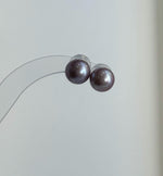 Purple Edison pearl jewelry set displayed beside a textured stone.