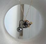 Ocean-inspired necklace featuring a Tahitian pearl and sculpted fish.