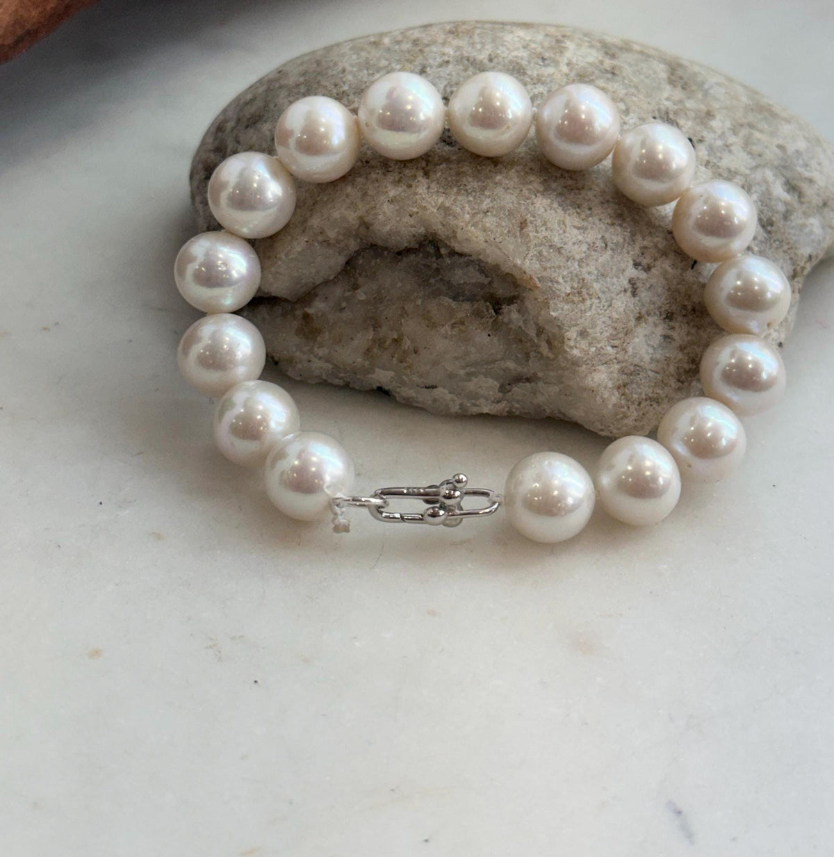 Sixteen luminous white freshwater pearls arranged in an elegant bracelet.