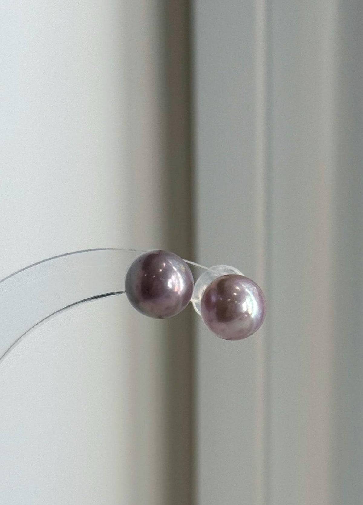 Pearl necklace and matching studs with soft pink and lavender tones.
