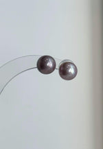 Pearl necklace and matching studs with soft pink and lavender tones.