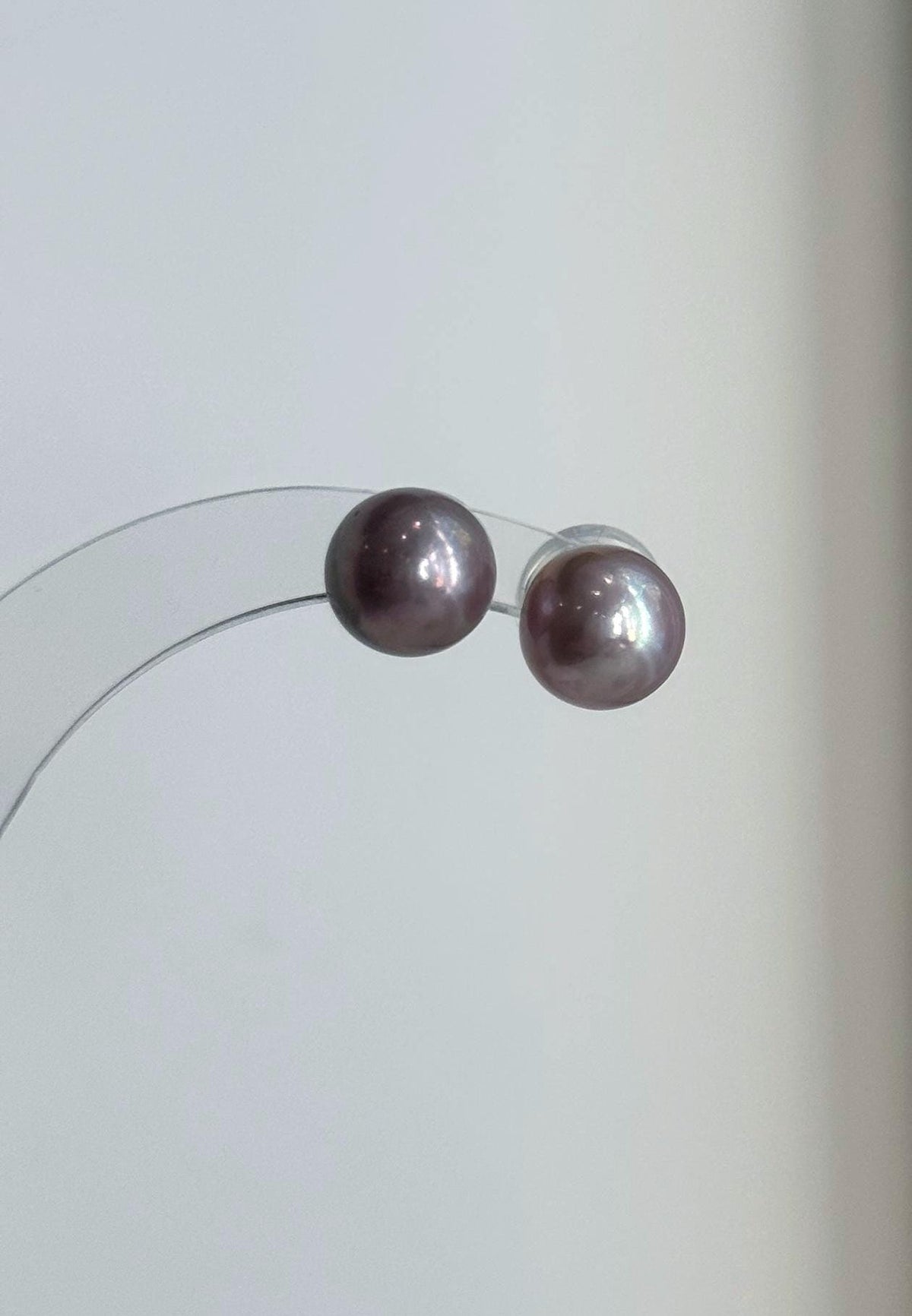 Pearl necklace and matching studs with soft pink and lavender tones.