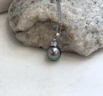 Genuine Tahitian pearl pendant necklace with a reflective green surface.