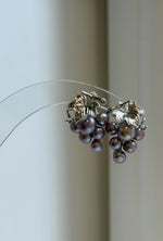 Purple and green keshi pearl earrings with mirror-like luster.