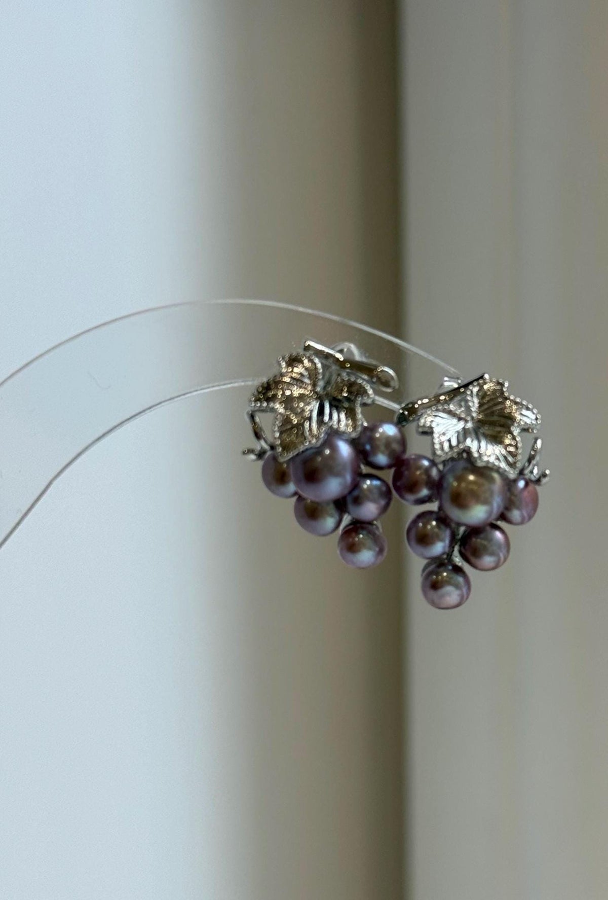 Purple and green keshi pearl earrings with mirror-like luster.