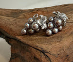Purple freshwater keshi pearls paired with green pearls in silver earrings.