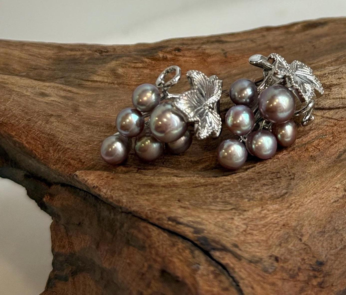 Purple freshwater keshi pearls paired with green pearls in silver earrings.