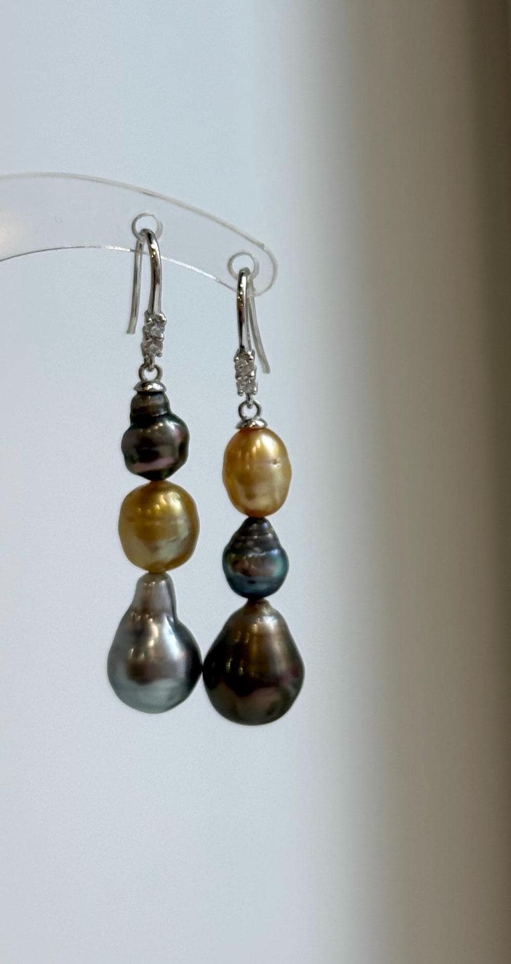 Golden, peacock, and silver-blue saltwater pearls arranged in long drops.