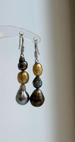 Golden, peacock, and silver-blue saltwater pearls arranged in long drops.