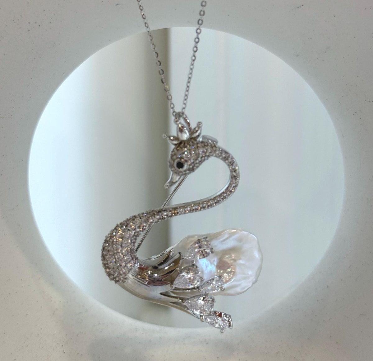 Crystal-accented swan jewelry with a lustrous baroque pearl body.