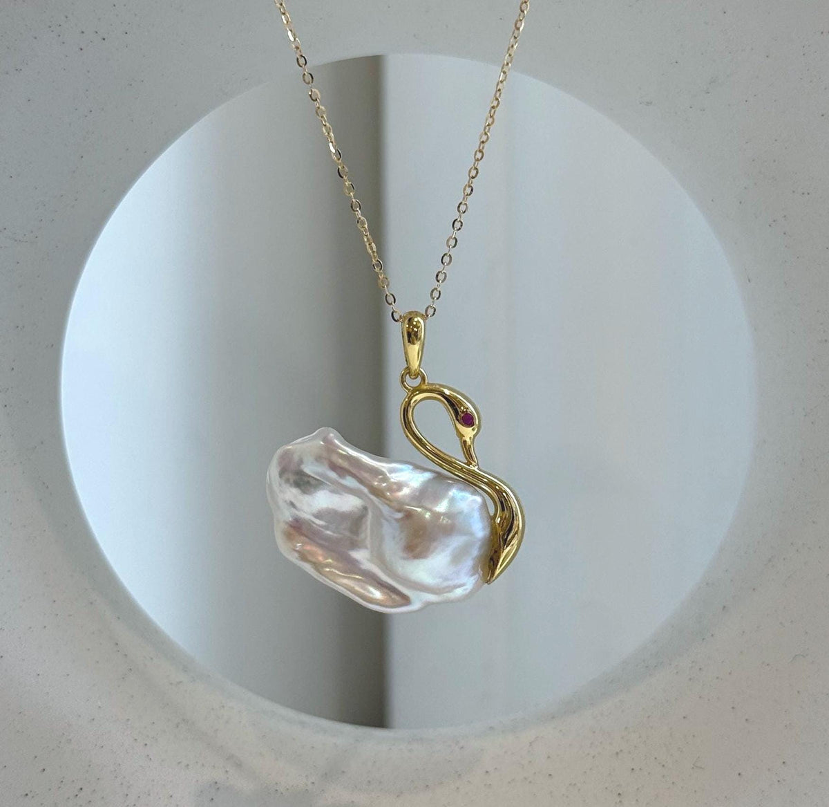 White baroque pearl pendant with blue and pink iridescent reflections.