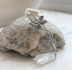 Floral pearl brooch featuring sparkling crystals and flowing silver-tone branches.
