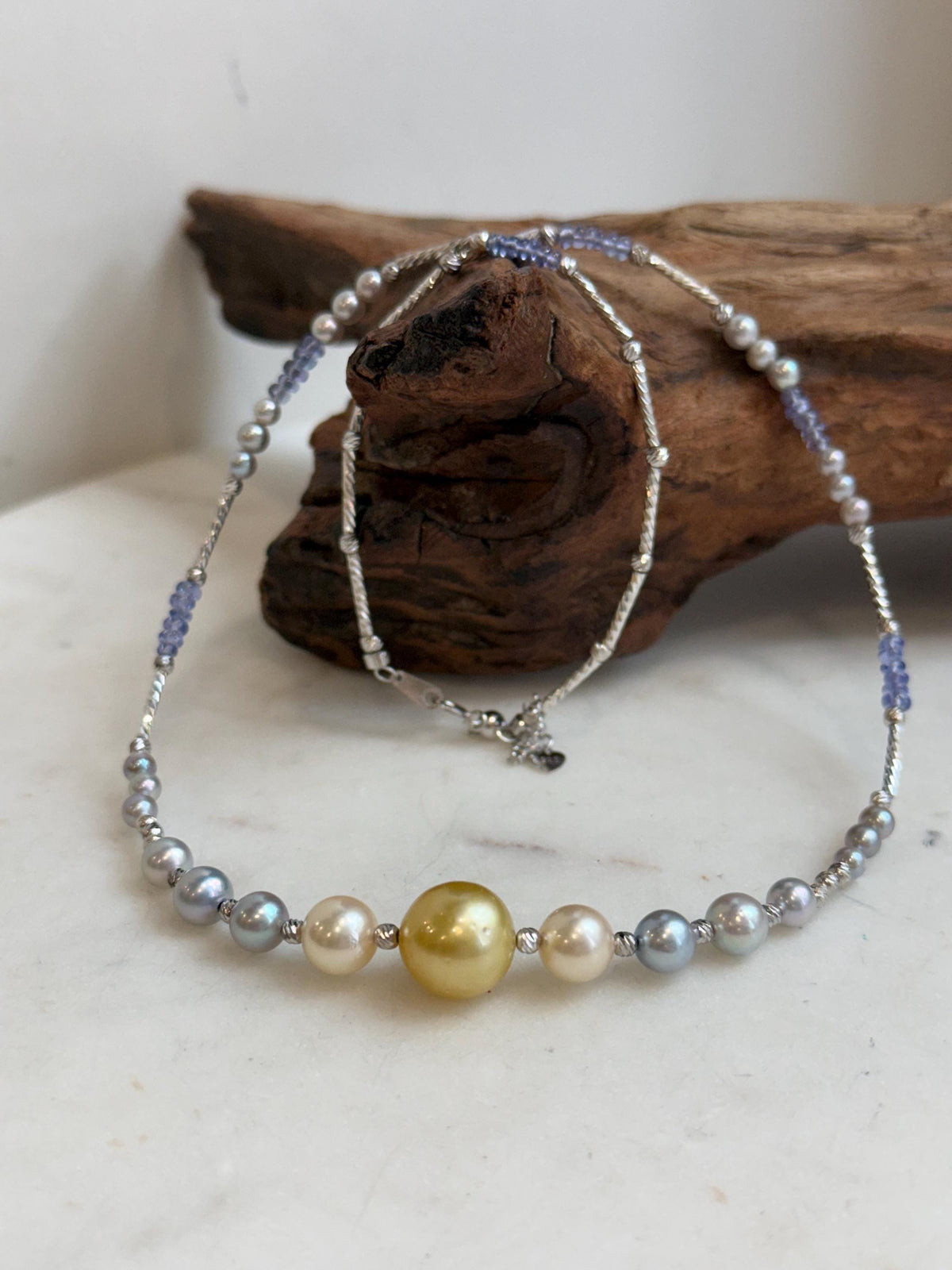 Graduated saltwater pearls with lustrous gold, cream and silver-blue tones.