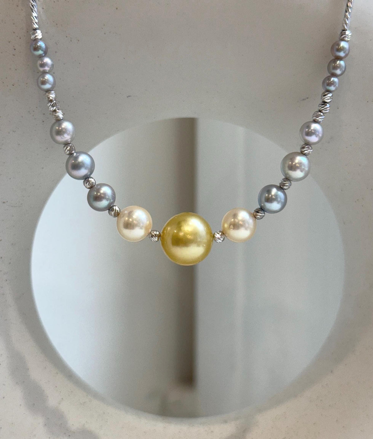 Pearl necklace with a silver clasp and extension chain visible at the back.