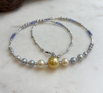 Saltwater pearl necklace with a golden center pearl and blue tanzanite beads.